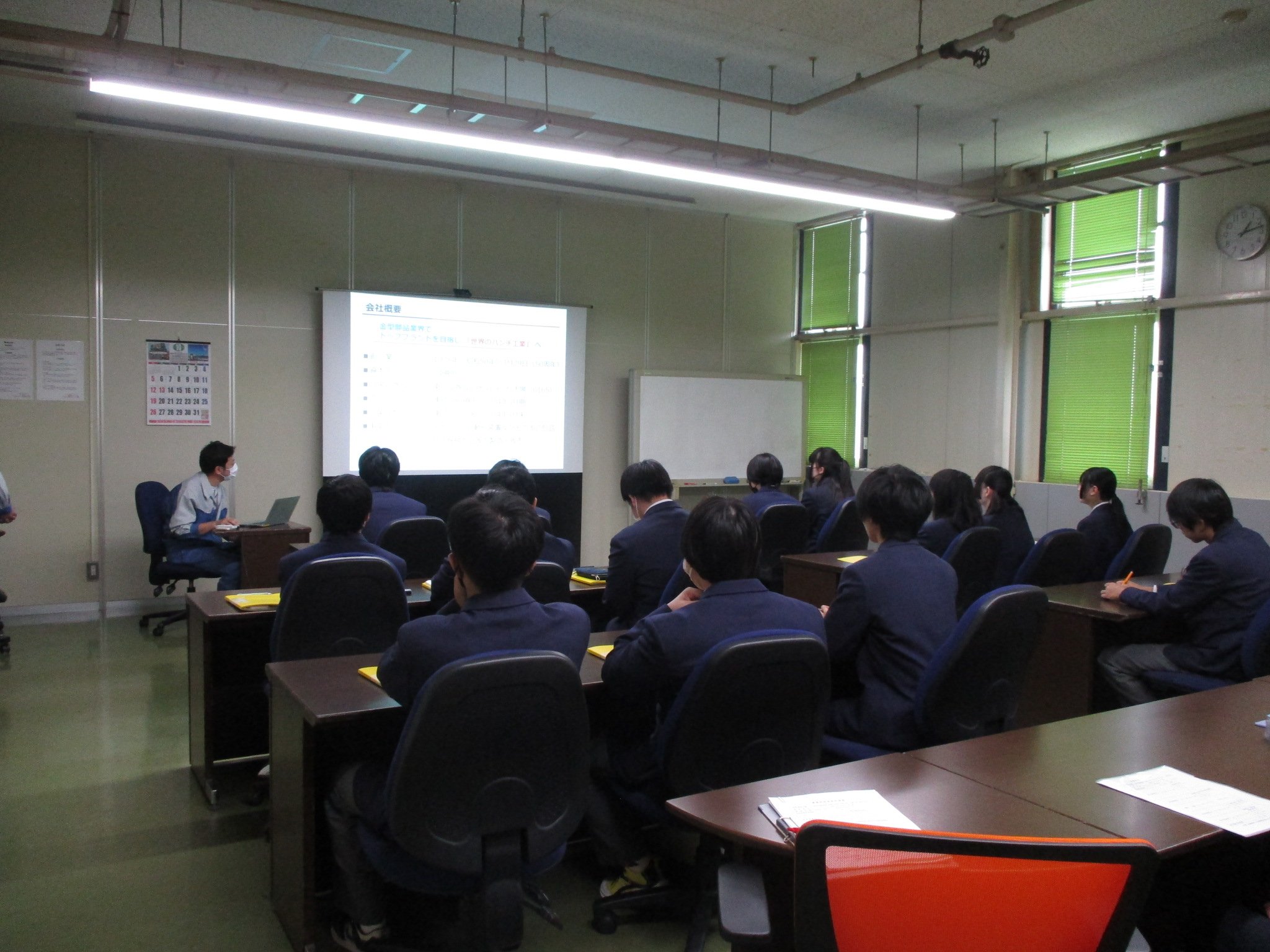 会議室で会社概要の説明を受ける高校生の後ろ姿